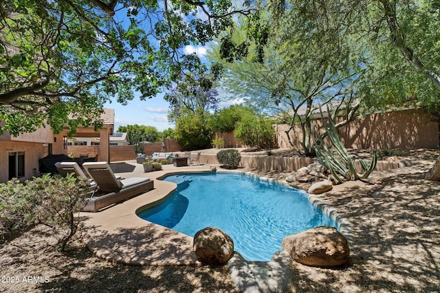 view of swimming pool featuring a patio, a fenced in pool, and a fenced backyard