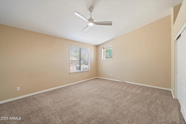 unfurnished bedroom featuring baseboards, a ceiling fan, light colored carpet, and lofted ceiling