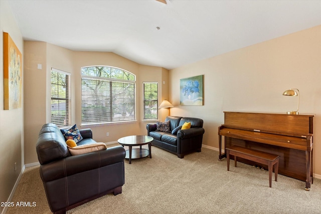 living area featuring baseboards, vaulted ceiling, and light carpet