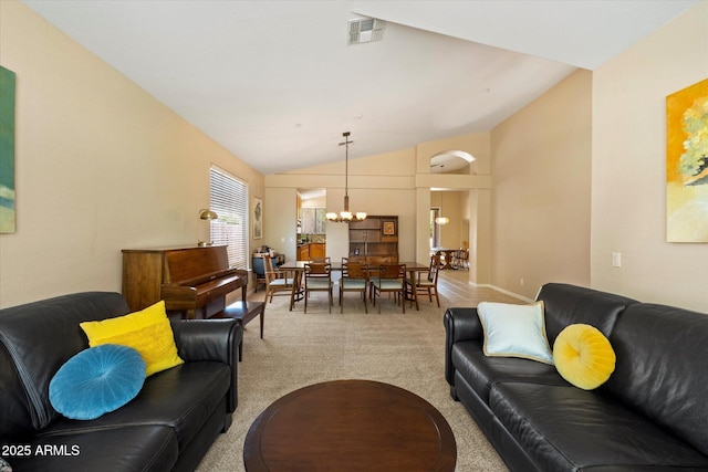 carpeted living room featuring baseboards, a notable chandelier, vaulted ceiling, and visible vents