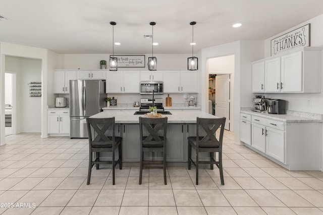 kitchen with light tile patterned floors, stainless steel appliances, and white cabinets