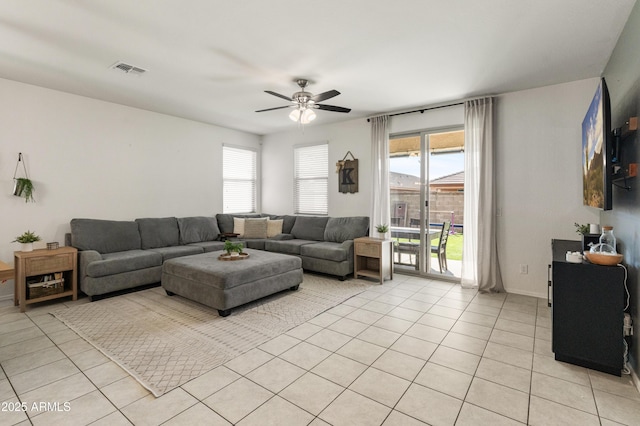 living area with light tile patterned floors, visible vents, a wealth of natural light, and ceiling fan