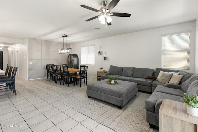 living area featuring light tile patterned floors, visible vents, and ceiling fan