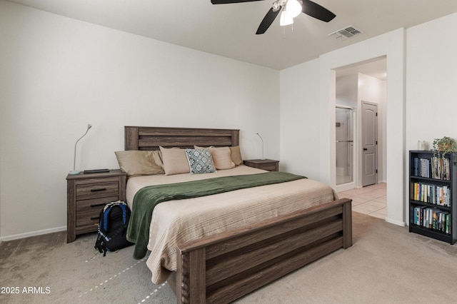 bedroom featuring a ceiling fan, visible vents, ensuite bathroom, and light carpet