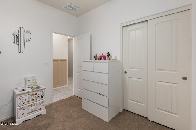 bedroom with visible vents, a closet, and carpet floors