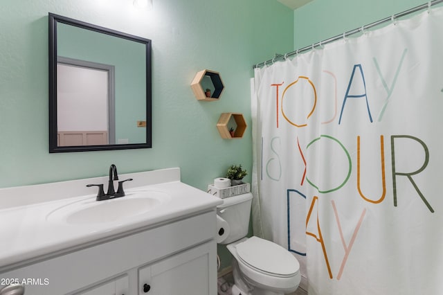 bathroom featuring toilet, vanity, and a shower with curtain