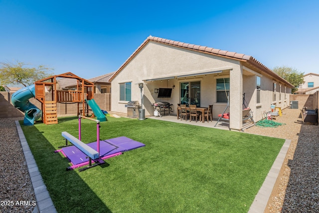 rear view of property featuring stucco siding, a patio, a fenced backyard, and a playground