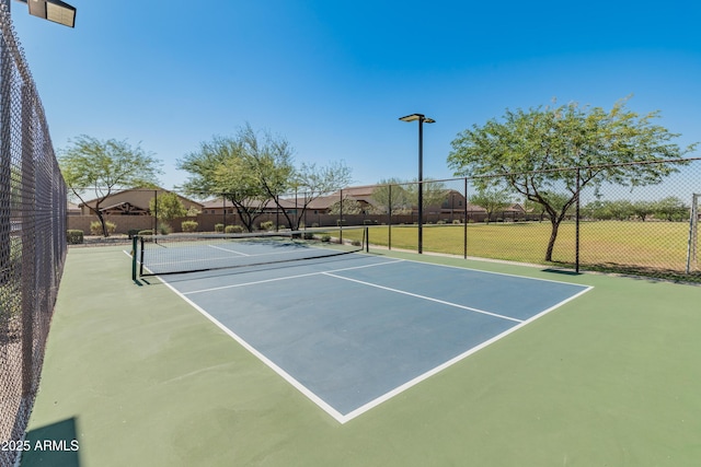 view of tennis court featuring fence