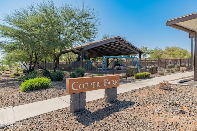 view of home's community featuring playground community and fence