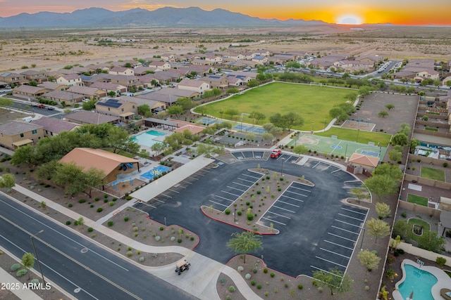 aerial view at dusk featuring a mountain view and a residential view