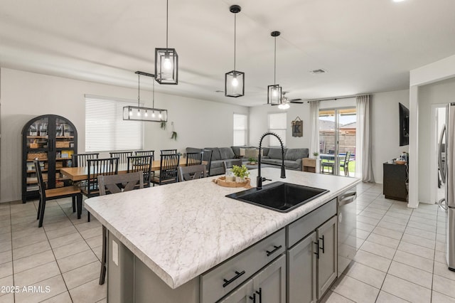 kitchen featuring a sink, open floor plan, gray cabinets, and light tile patterned floors