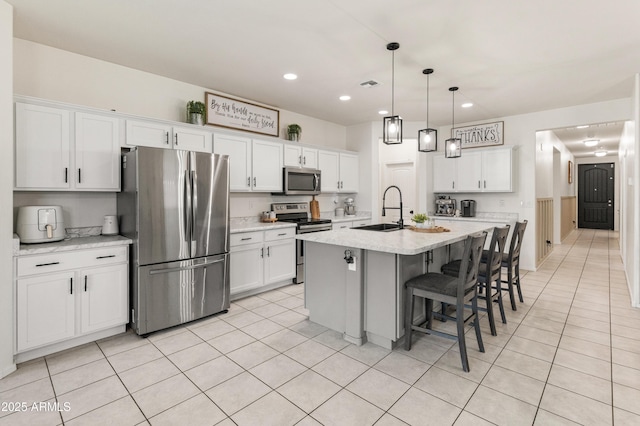 kitchen with white cabinets, appliances with stainless steel finishes, and a sink