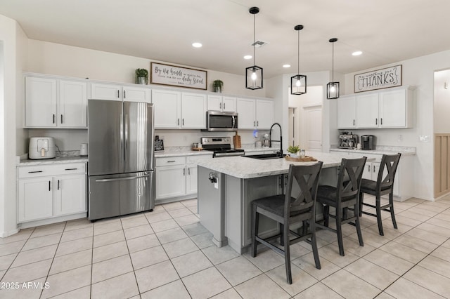 kitchen featuring a sink, white cabinets, light tile patterned floors, and stainless steel appliances