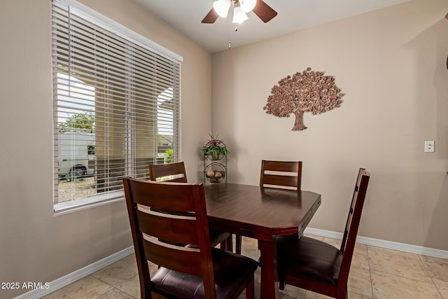 dining space featuring light tile patterned flooring, baseboards, and ceiling fan