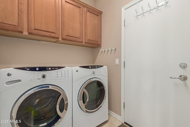 clothes washing area featuring washer and dryer, cabinet space, and baseboards