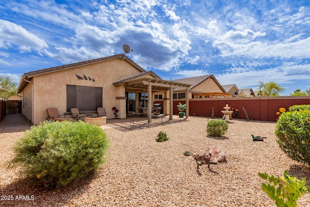 rear view of property with a patio, fence, an outdoor fire pit, a pergola, and stucco siding