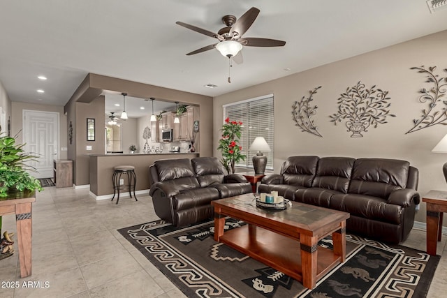 living room featuring light tile patterned floors, visible vents, baseboards, and ceiling fan