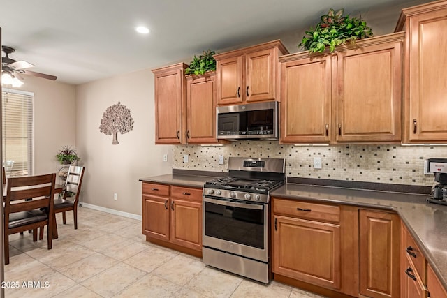 kitchen featuring dark countertops, backsplash, stainless steel appliances, and a ceiling fan