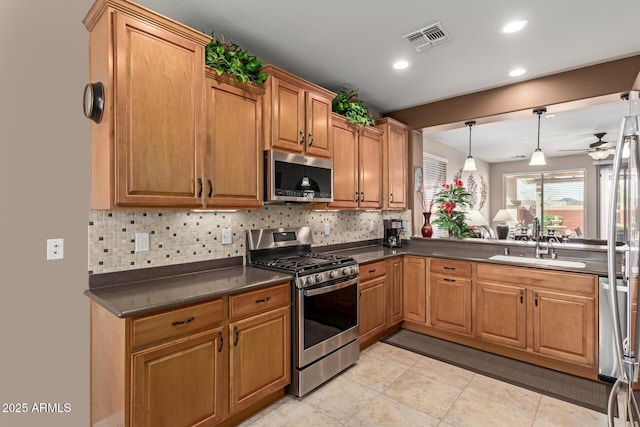 kitchen featuring dark countertops, visible vents, backsplash, ceiling fan, and stainless steel appliances