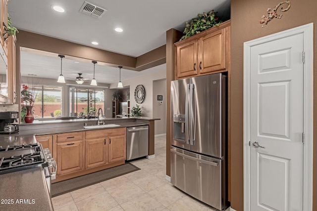 kitchen featuring a ceiling fan, visible vents, a sink, appliances with stainless steel finishes, and dark countertops