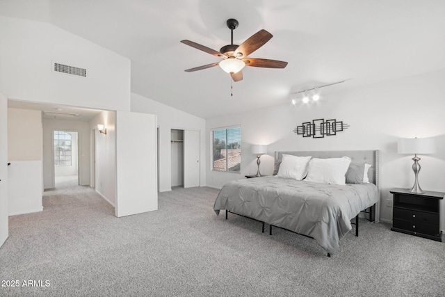 bedroom with multiple windows, visible vents, vaulted ceiling, and light colored carpet