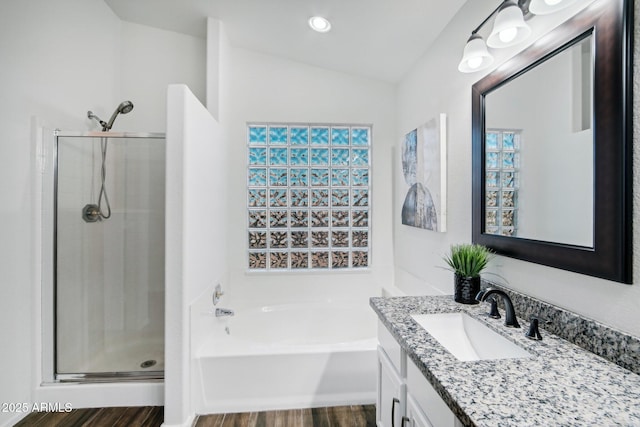 full bath with lofted ceiling, a stall shower, a bath, and vanity