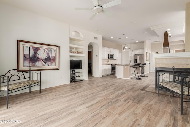 12841 N 19th St, Phoenix, AZ 85022 - living room featuring a ceiling fan, light wood-style flooring, visible vents, and built in shelves