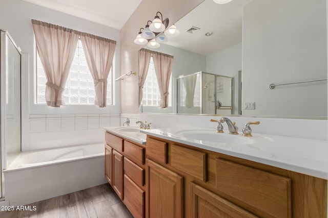 12841 N 19th St, Phoenix, AZ 85022 - full bath with visible vents, a shower stall, double vanity, wood finished floors, and a sink