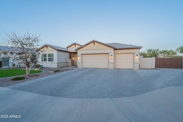 view of front of home with a garage, a gate, fence, decorative driveway, and board and batten siding