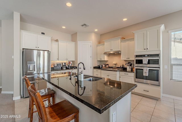 kitchen featuring stainless steel appliances, visible vents, white cabinets, a sink, and under cabinet range hood