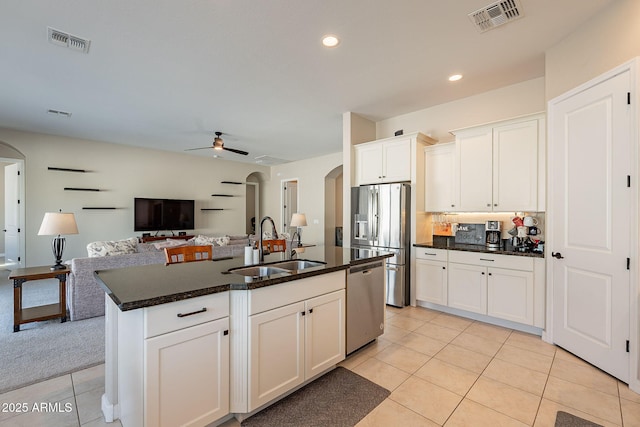 kitchen featuring appliances with stainless steel finishes, arched walkways, visible vents, and a sink