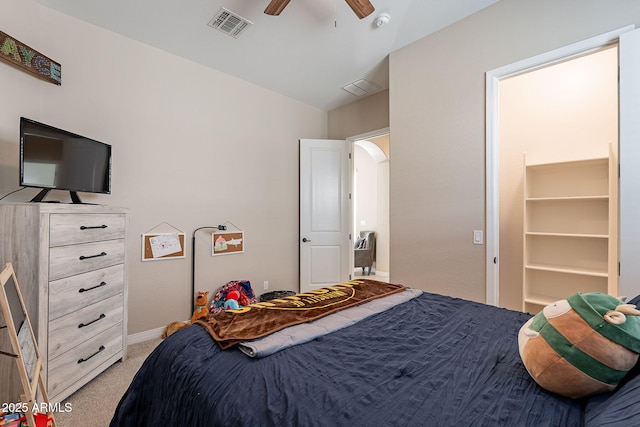 bedroom with light carpet, visible vents, arched walkways, and a ceiling fan