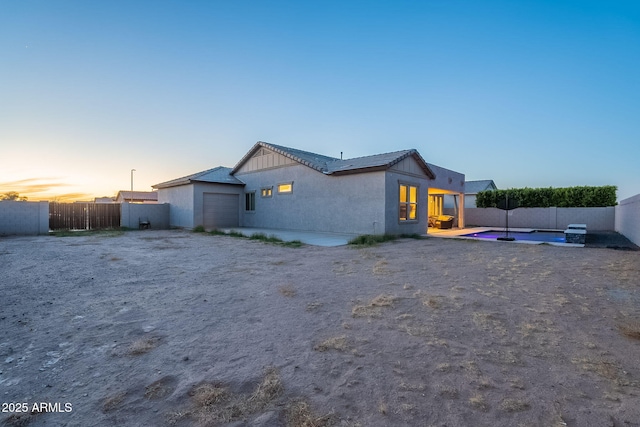 exterior space with a fenced backyard, a patio, an attached garage, and stucco siding