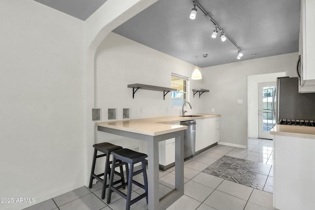kitchen with white cabinets, stainless steel appliances, open shelves, and light countertops