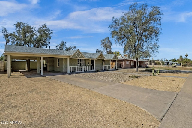 ranch-style home featuring driveway, a carport, and covered porch
