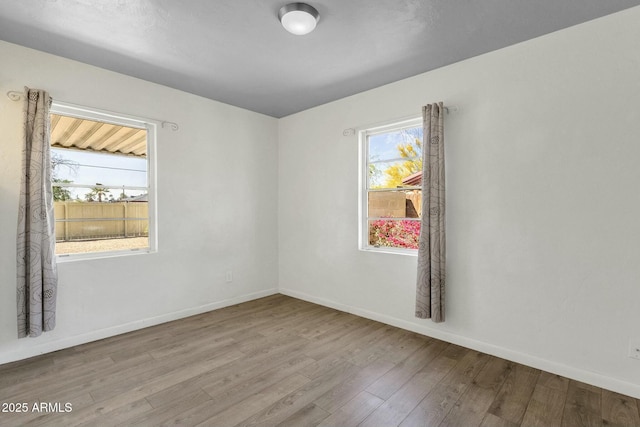 empty room with baseboards and wood finished floors