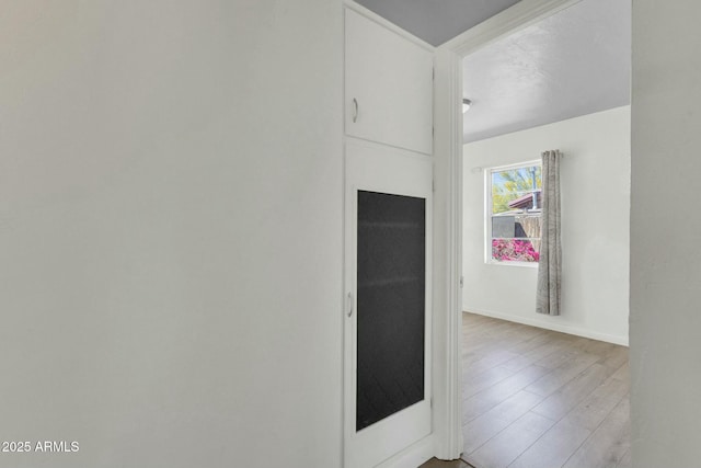 interior space with baseboards and wood finished floors