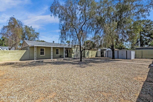 exterior space with a shed, an outdoor structure, and fence