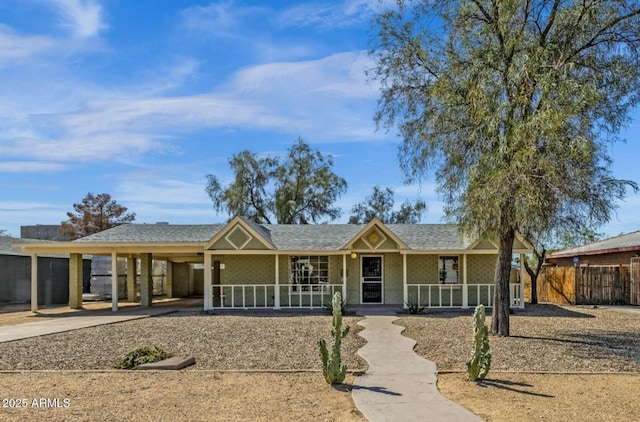 ranch-style house featuring fence, concrete driveway, an attached carport, roof with shingles, and a porch