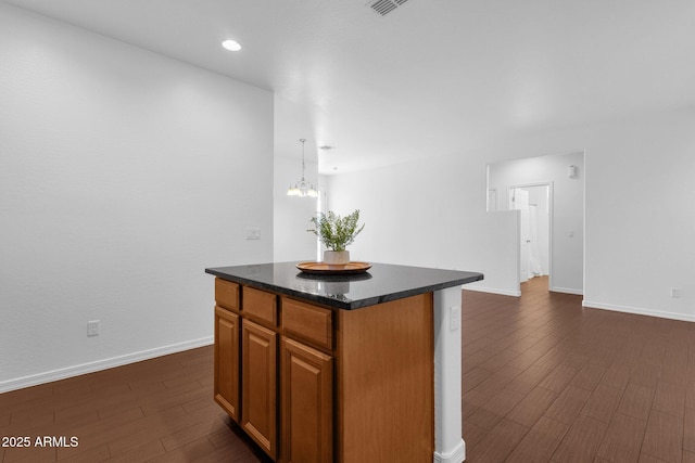 kitchen featuring pendant lighting, a center island, dark wood-type flooring, and a chandelier