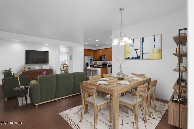 dining space with hardwood / wood-style flooring and a notable chandelier