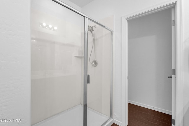 bathroom featuring wood-type flooring and an enclosed shower