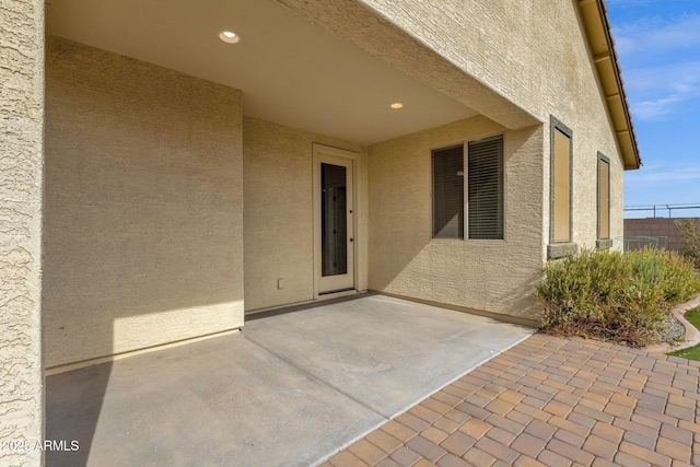 view of exterior entry with a patio