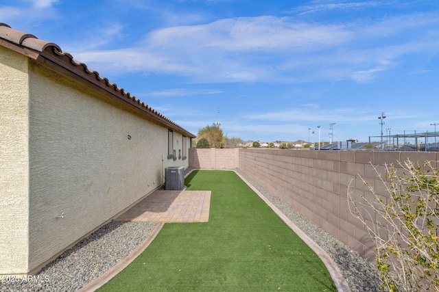 view of yard with central AC unit and a patio area