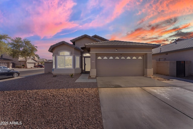 view of front of home featuring driveway, an attached garage, and stucco siding