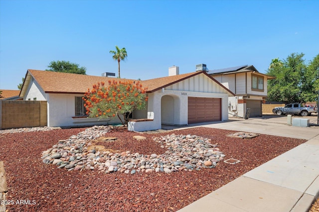 3021 E Harmony Cir, Mesa, AZ 85204 - view of front facade featuring an attached garage, driveway, a chimney, solar panels, and board and batten siding