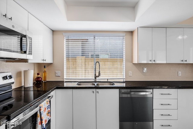 3021 E Harmony Cir, Mesa, AZ 85204 - kitchen featuring stainless steel appliances, a tray ceiling, white cabinetry, dark stone counters, and a textured wall