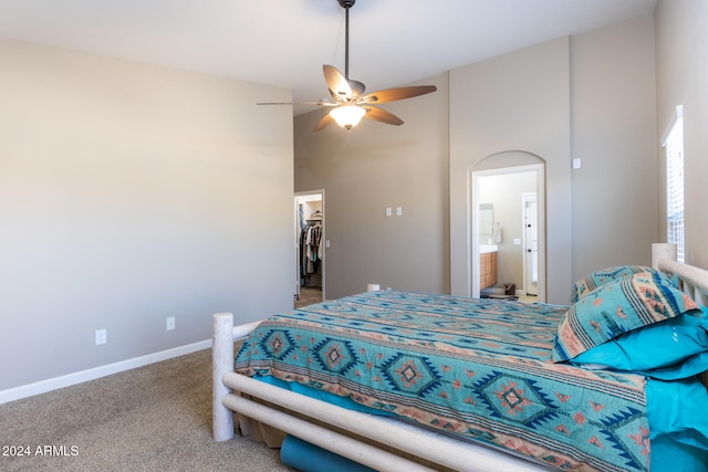 carpeted bedroom with a high ceiling, ensuite bathroom, ceiling fan, a spacious closet, and a closet