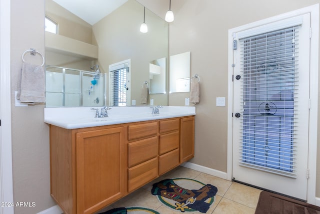 bathroom with tile patterned flooring, a wealth of natural light, walk in shower, and vanity