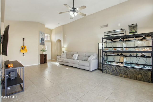 living room featuring ceiling fan, light tile patterned flooring, and vaulted ceiling